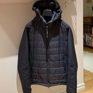 Cp Company jacka - En fin Cp Company jacka för året runt. Glasögonen går att fälla in i luvan, luvan är även avtagbar. Plasten är kvar på glasögonen eftersom dom är aldrig använda. Skick 8/10. Storlek 46 (s/m). Nypris 4300kr