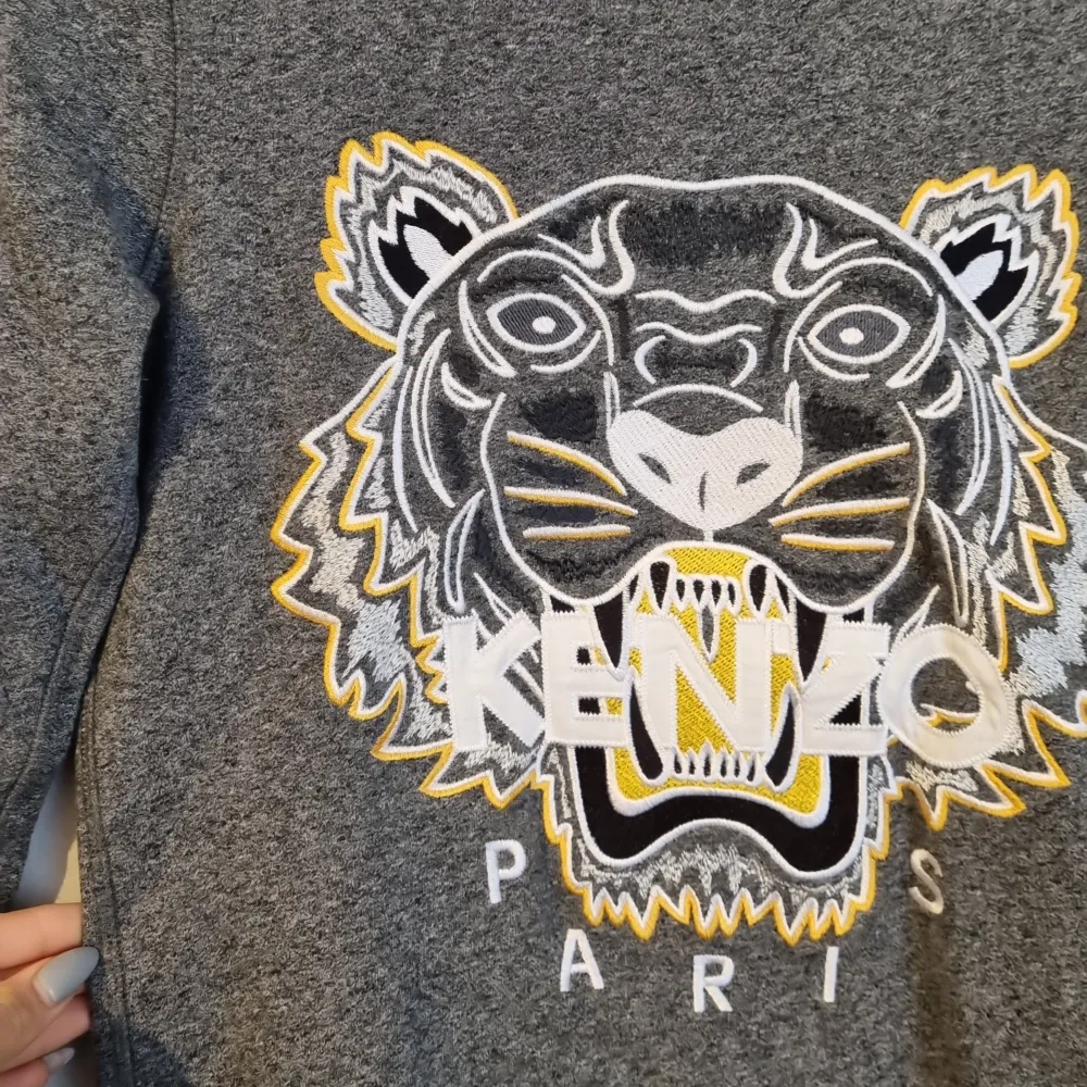 En superfin tröja från Kenzo Paris. Tröjan är i storlek S och säljs då min son vuxit ur den. Den är i ett väldigt bra skick och knappt använd.. Hoodies.