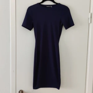 Tight mörkblå klänning - En tight, mörkblå, lite randig textur från Boohoo. Väldigt bra basplagg som man kan styla till mycket!