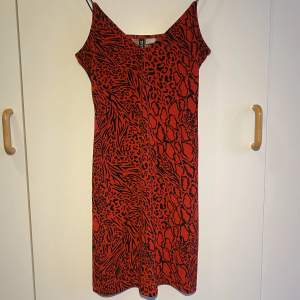 En röd kort klänning med leopardmönster. Den är töjbar men sitter tajt, tunna axelband. Storlek S. Knappt använd