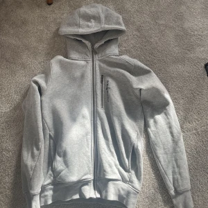Grå Sail Racing zip hoodie. - En grå Sail Racing zip hoodie i bra skick. Köpte för ett år sedan och har knappt användt den. Dragkedjan funkar utmärkt och inga fläckar finns överhuvudtaget.
