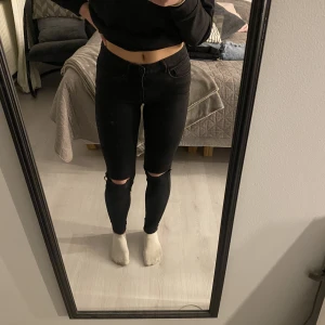 Svarta jeans med slitningar - Säljer dessa svarta jeans från Only med hål på knäna då de inte kommer till användning. De är lågmidjade och lagomt väl använda.