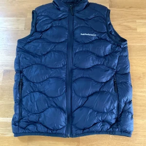 Peak Performance väst stlk 170 - Peak Performance väst: en fin väst i bra skick i storlek 170, endast ett litet märke i nedre delen av ryggen och därav det låga priset. Pris: 400kr   Köpare står för frakt