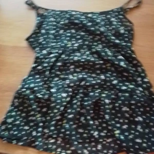 Stockholm stil tröja - Den här tröjan är lite Stockholm stil och den är väldigt fin. Den är svart men lite genomskinlig och så har den lite gula blommor på sig. 