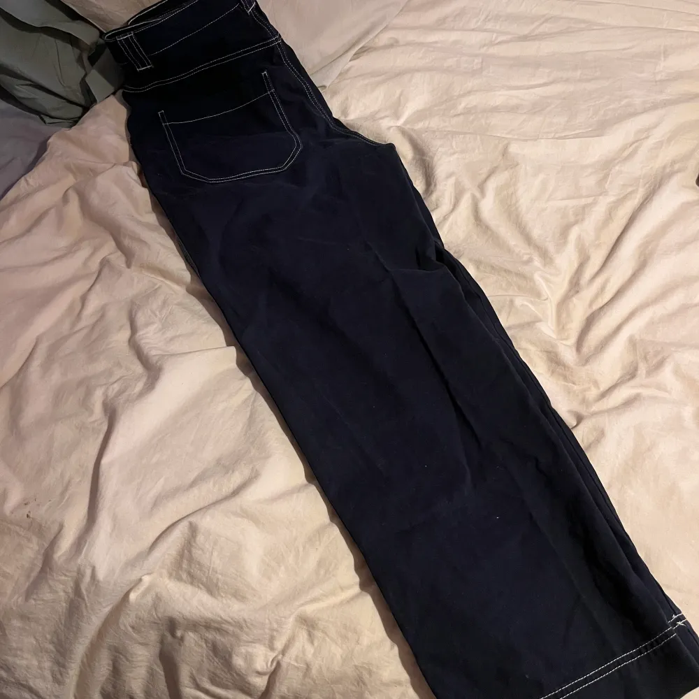 Navyblå byxor med vita streck från weekday. Bra passform, kan passa 38 . Jeans & Byxor.
