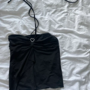 Tub topp - Jätte gullig tub topp från shein, storlek M. Använd en gång men i bra skick. Köpt för 90kr. Har ett hjärta mellan bysten vilket är jätte fint och två band som man kan välja lite hur man vill knyta runt halsen