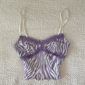 Lila och vitt linne - Ett lila och vitt gulligt zebra liknande linne med spetsdetaljer. I superbra skick och nästan aldrig använt, i storlek 36💜💜