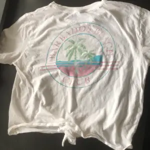 A white crop top with a graphic design on the back (it says Barbados Beach Club, Barbados Beach on front). Size M, from H&M originally.
