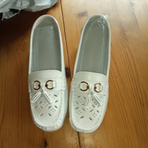 Vita skor med fransar fram stl 40 . - Helt nya och oanvända vita skor med fransar fram stl 40 .mjuka och goa för foten. Hämtas i Skene alt skickas o köpare betalar frakten o Swishbetalning tillämpas .frakt inräknat i priset .99 kr.