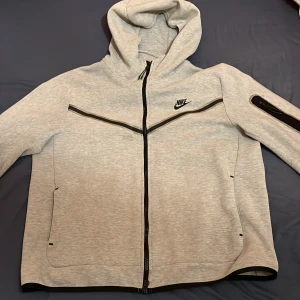 Nike tech fleece grå storlek L passar M - Den är använda Max 4 gånger och på andra bilder ser man att kedjan är lite trasig men det går fortfarande att använda den. Pris kan diskuteras.