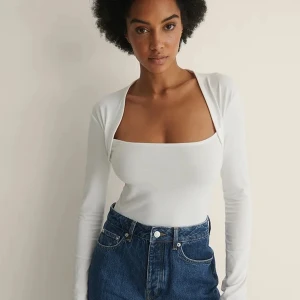 Vit topp med bolerodetalj - Säljer denna supersnygga topp med bolerodetalj/ fyrkantig halsringning! Säljer då jag inte trivs i vitt, helt slutsåld  100 + frakt