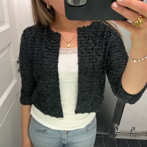 Jättefin kofta! - Säljer min fina glitterkofta i mörkgrå💕 Nästan aldrig använd och i jättefint skick! Passar perfekt till fest och finare tillfällen. Liten i storleken så skulle säga att den passar även S