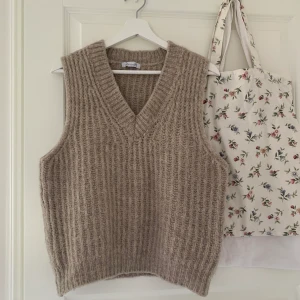 Stickad väst - Stickad beige v-ringad väst från Designbysi, bra skick, köpt på Sellpy men har aldrig använt själv