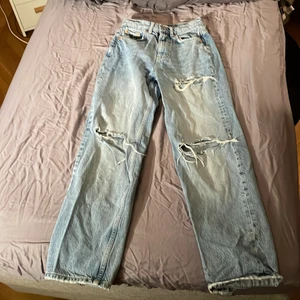 Jeans från Gina tricot i storlek 32 - Ett par blå jeans från Gina ”perfect jeans” i storlek 32. Köptes för va 1 år sedan men använts ca 5 ggr så de har legat i garderoben ett tag. Det är ingen bild på mig pga att de är alldeles för små så jag inte ens får på mig de. Jag har vanligtvis ca 36 i byxor. Säljer då pga av att de är för små och att jag ej använder jeans längre. De är breda jeans med fickor bak och fram, tre ”hål” och har heller. De är högmidijade.