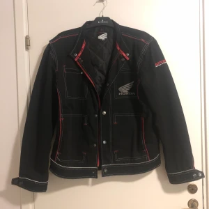 Honda Workwear jacka i storlek M - Svart och röd jacka i bra skick! Storlek M, men passar även till L. Fodrad inuti med reflexer utanpå. Skicka gärna meddelande om ni har någon fråga!