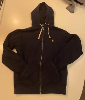 En marinblå polo ralph lauren zip hoodie i storlek S. Tröjan är i ett bra skick. (Se bild)
