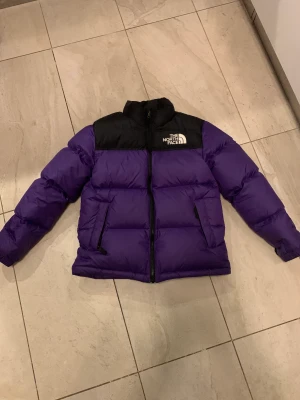 The north face puffer jacket  - Säljer min lila the north face puffer jacket. Perfekt skick(10/10) storlek 158cm men passar på mig som är 161cm.