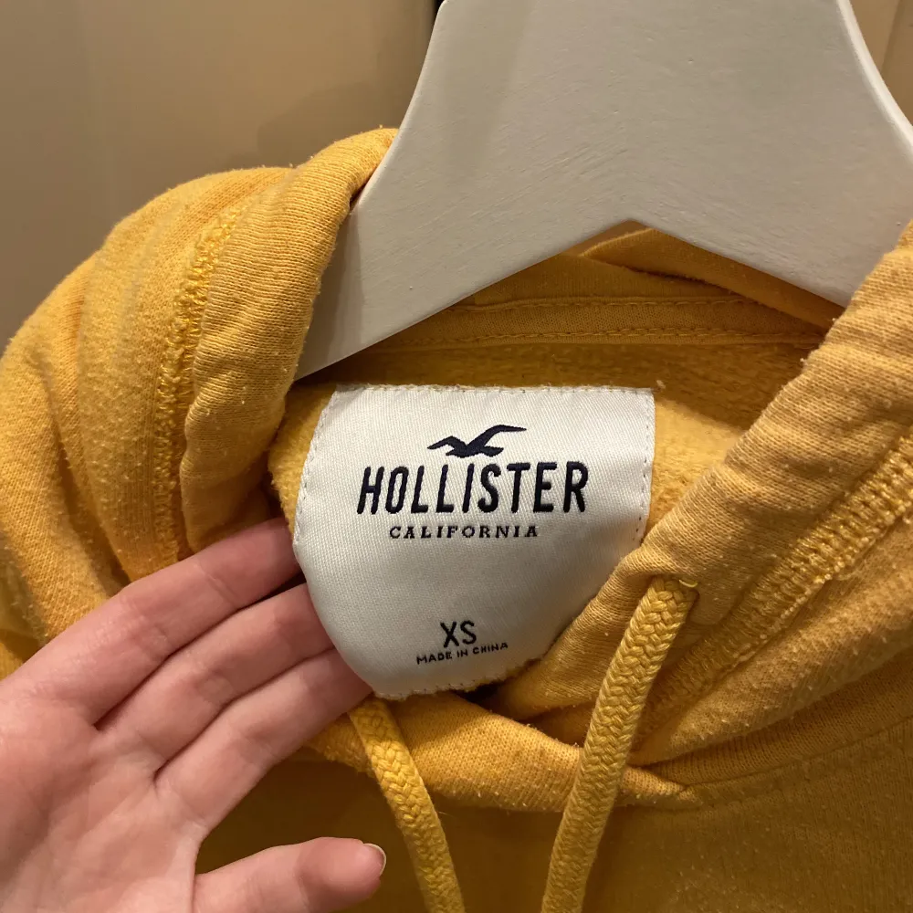 Croppad tröja med luva i jättefin solgul färg från Hollister. Bra skick. Säljer då den börjar bli lite liten.☀️. Hoodies.
