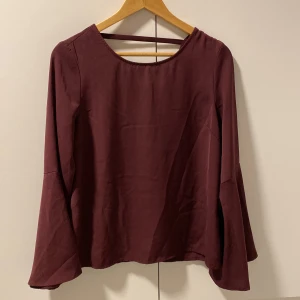 Vinröd blus - En väldigt fin vinröd tröja med volanger på armarna med öppen rygg