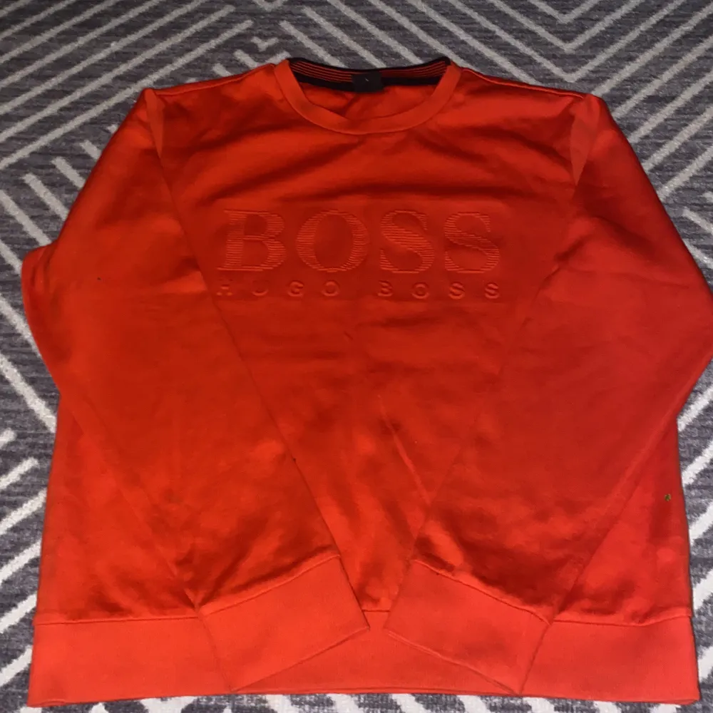 En Röd/Orange Boss tröja i storlek L. Den är Slim Fit och för män men passar lika bra för kvinnor. Använd en gång. . Tröjor & Koftor.