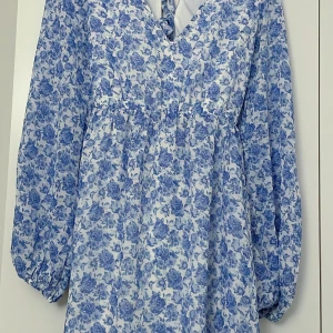 Blommig klänning  - Fin blommig klänning från NA-KD i mycket fint skick. Öppen rygg med knytning 