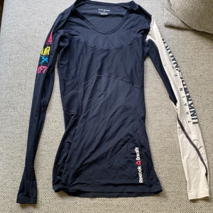 Reebok - Reebok Crossfit tröja i storlek S. Inga skavanker, använd få ggr. Tunn och luftig tröja men samtidigt en kompression känsla. Marinblå färg. Köparen står för spårbart frakt 59kr