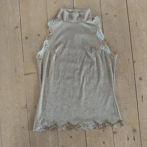 Gul halterneck - Färgen är lite smutsgul/pastellgul. Passar en S eller liten M. 