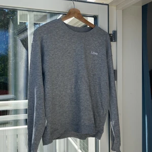 Grå sweatshirt med ”Love” påsytt - Basic sweatshirt från HM med ”Love” påsytt. Sista bilden visar färgen bäst. Inga defekter tröjan är så gott som ny. Frakten ingår i priset❤️