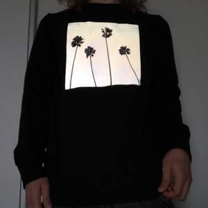 En tuff sweater från H&M med palmer. Printet på tröjan lyser upp när man tar en bild på den med blixt.