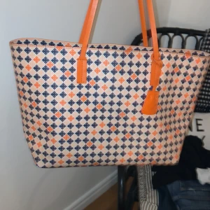 By malene birger väska orange  - Säljer denna fina väskan från by malene birger då den inte kommer till någon användning längre, den är rymlig och får plats med det nödvändiga. Den är i fint skick bortsätt från slitaget på banden (se bild 2) men det är inget som gör någon större skillnad