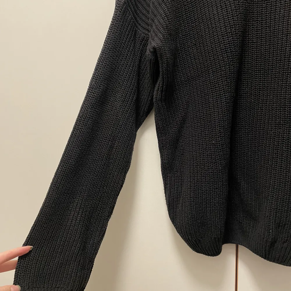 En fin stickad tröja med v-ringning i ryggen. Går även att vända på tröjan och få ringningen på framsidan. Den är använd men fortfarande i ett bra skick. . Stickat.