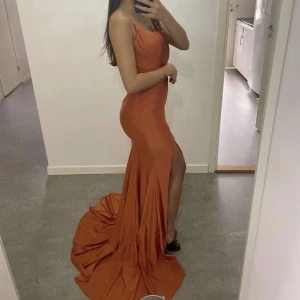 Klänning - Säljer min fina klänning i storlek US 2, motsvarar storlek 34. Är andra ägare därav billigare pris.  Klänningen har en slits på vänstra benet och en rosett runt magen. Klänningen är enkel men sticker ut ändå. (Priset kan diskuteras) 