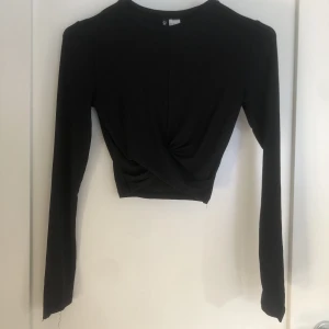 Långärmad topp - Säljer denna svarta långärmade toppen med en slags Knut på framsidan❤️Sömmen har gått upp lite på ena ärmen men lätt att sy ihop. Från H&M, Nypris: 150 kr. Kom privat för frågor eller bilder❤️
