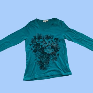 Tröja med tryck - Tröja med 3/4 ärmar och tryck. Trycket är svart och har glitter. Färg: Blå Material: 95% bomull, 5% spandex. Mycket stretch. Om du har några frågor eller vill se mer bilder är det bara att skicka iväg ett meddelande:)