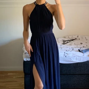 Superfin balklänning - Marinblå balklänning med glitter runt halsen och på banden. Passar mig som är 170 och har S eller strl 34. 