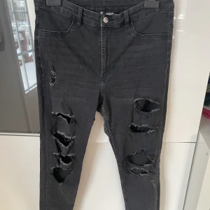 Långa svarta smala jeans med hål på framsidan  - Långa svarta smala jeans med hål på framsidan. HM storlek 44