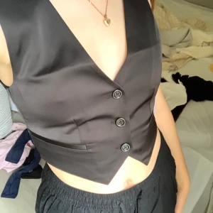 västtopp - cool svart västtopp från nelly! storlek XS. i nyskick då den aldrig är använd, lappar är kvar. köparen står för frakten som ingår i annonspriset (66kr)