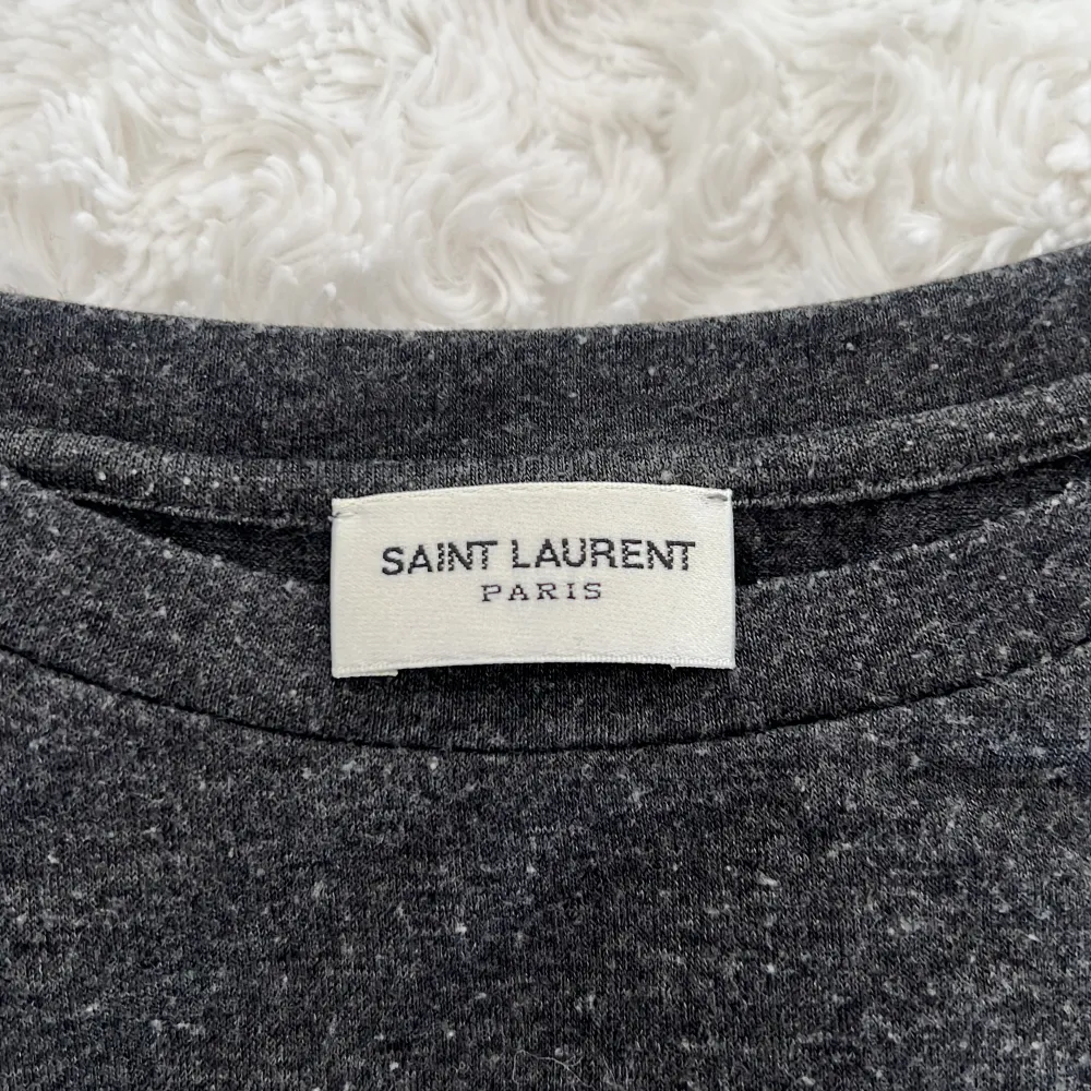 Äkta Saint Laurent t-shirt säljes  Köptes för ca 1år sen, använt ca 2-3 gånger Otroligt skönt material!!    Storlek S   Ordinarie pris ca 2000-3000kr  Mitt-989kr Pris kan förhandlas  Men säljes billigt pga utrensning. T-shirts.