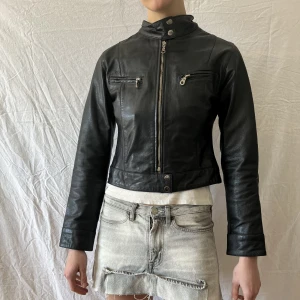 Kort mc-jacka  - Kort skinnjacka med mc-detaljer. Använd ett fåtal gånger.