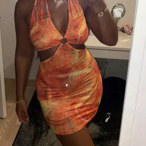 En oanvönd mönstrad orange kort klänning för 49kr