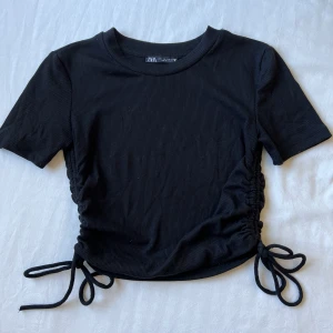 Tshirt - T-shirt med dragsko i sidorna, storlek s. Använd 1-2 gånger. 