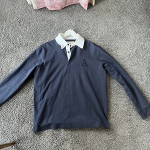 Långärmad piké, a days march - Fräsch långärmad piké från a days march. Använd knappt en gång så i princip helt ny. Marinblå färg med vit krage. 