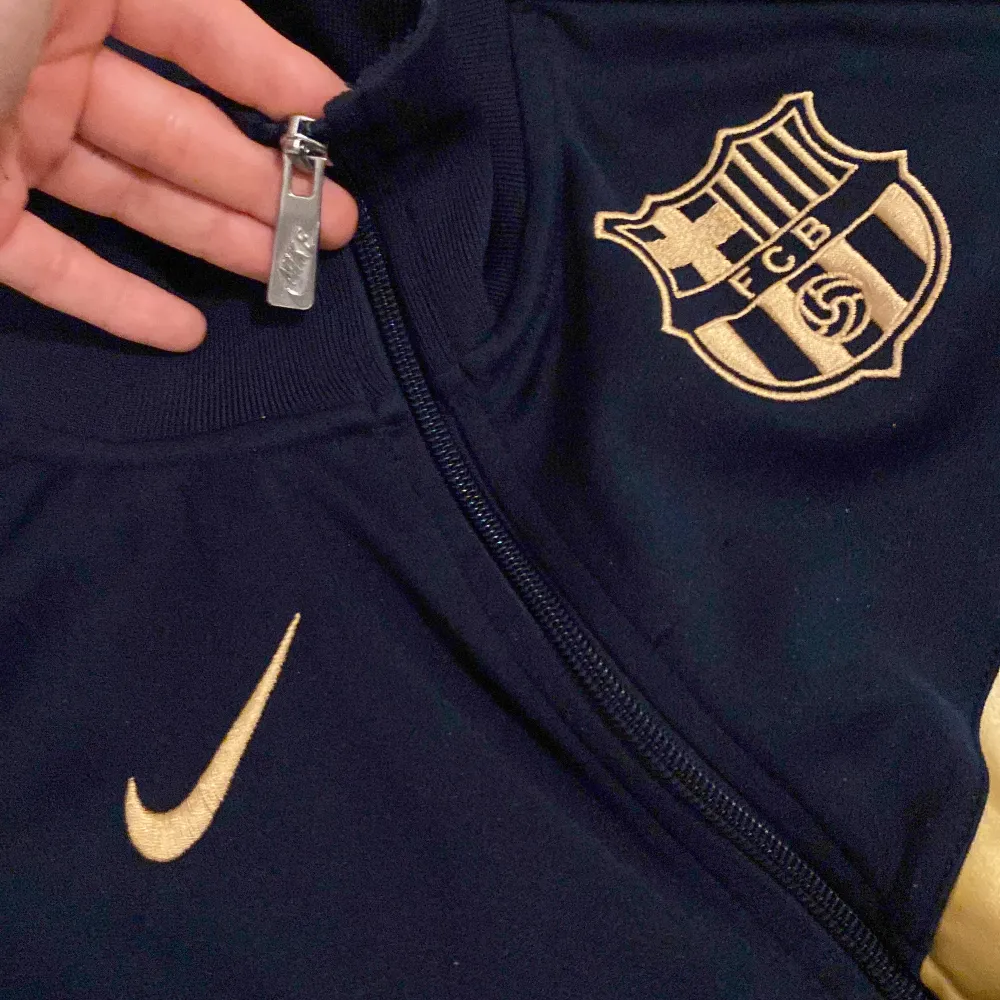 Nike Barcelonas 2011/2012 kofta, har fickor, är lite riven vid ärmen som ni kan se i bilden men det är inget hål :) är i stålande bra skick. Kostar runt 500-700 kr när ANDRA säljer den då den är så oss gammal att den inte säljs längre i nike etc, mörkblå . Tröjor & Koftor.