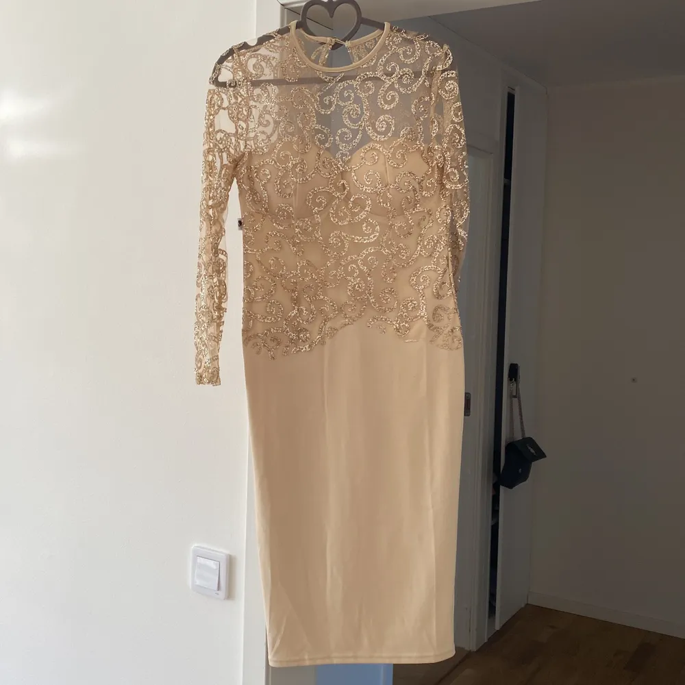 En super fin klänning från Dennis Marglic i guld med guld glitter. Klänningen är lite längre och är öppen i ryggen. . Klänningar.