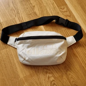 Vit magväska Ellesse - Vit/offwhite magvärken från Ellesse. Aldrig använd. Mått 24x16 cm.