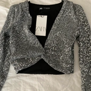 Zara festtopp strl s - Jag köpte denna superfina topp från Zara för en månad sen, dessvärre passade den inte mig så bra. Så nu undrar jag om det finns ett intresse, den är oanvänd med lappen kvar. Skriv vid intresse och för fler bilder! Fraktkostnad står köparen för. 