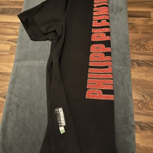 Tshirt - Philipp Plein - En Philipp Plein tshirt som är icke autentisk säljs för endast 449kr! Mycket bra kvalité, den är även stretchig och knappast använd. Den är  så gott som nyskick. För dig som bär storlek M.
