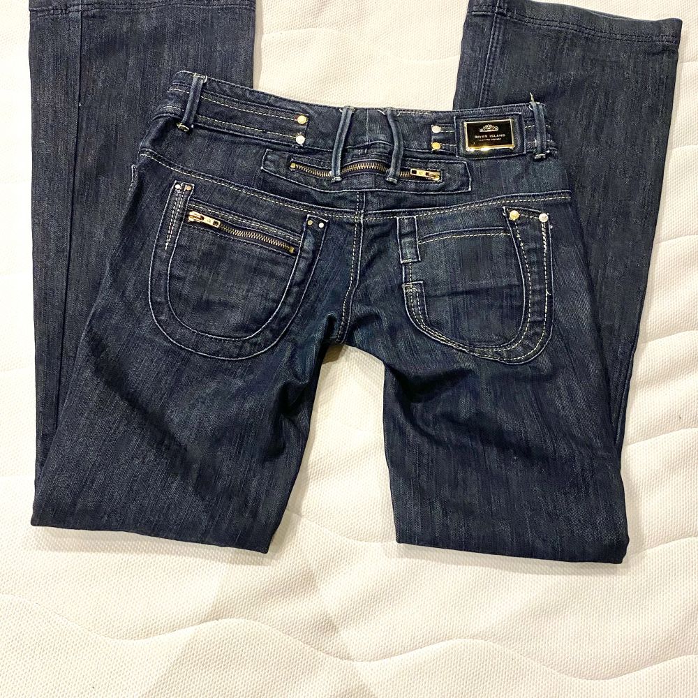 Lågmidjade jeans med sjukt coola bakfickor. Jeansen är utsvängda/raka och har många guld detaljer. Dom är i bra skick har inga hål, fläckar osv. Innerbenslängd: 83cm Midjemått: 40cm Köpare står för frakten💗. Jeans & Byxor.