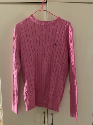 Kabelstickad tröja  - Rosa kabelstickad tröja från Morris! Jätteskönt material och i bra skick trots köpt second hand! Använd kanske 5 ggr max! Säljs eftersom den inte kom till användning!