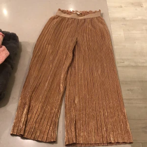 Glansigt Set - Rosa glansigt set. Byxorna i storlek 140. Och tröjan i 146/152